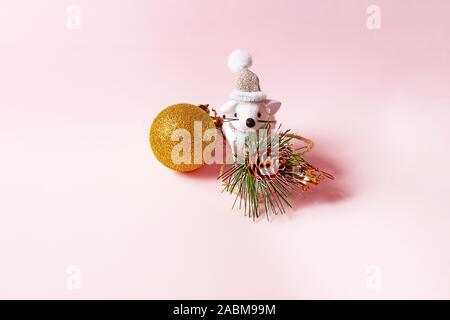 Carino piccolo mouse con palla di Natale è seduto in uno sfondo rosa. Presente per Capodanno e Natale. Foto Stock