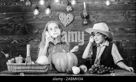 Gli agricoltori per bambini ragazza ragazzo verdure raccolto. Bambini presentando farm raccolto lo sfondo di legno. Azienda agricola a conduzione familiare. Motivi per cui ogni bambino dovrebbe sperimentare l'agricoltura. Responsabile per il daily farm faccende. Foto Stock