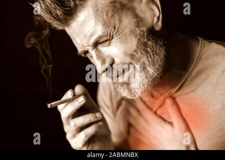 L'uomo fuma sigarette e ha problemi con i polmoni nella parte anteriore del fondo nero. Dipendenza dalle sigarette concept Foto Stock