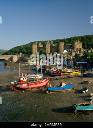 Visualizza S da Conwy cinta muraria, Wales, Regno Unito, mostrando il fiume e il porto con la C castello13th al di là. La barca in primo piano L viene verniciato di rosso. Foto Stock