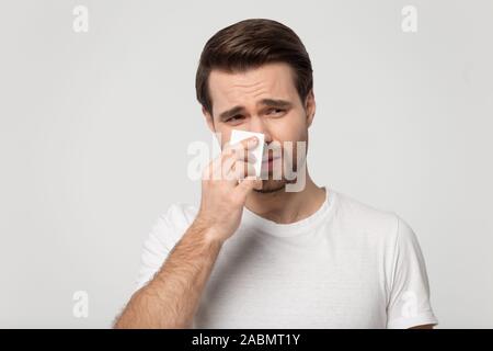 Infelice giovane di utilizzare carta tessuto senso di malessere Foto Stock