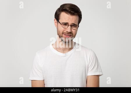 Infelice uomo caucasico isolato in studio il pianto dei problemi Foto Stock