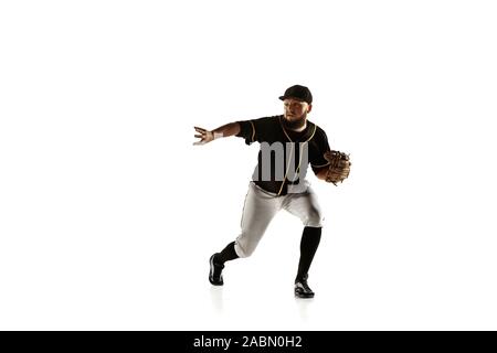 Giocatore di baseball, bricco in un nero uniforme di pratica e formazione isolata su uno sfondo bianco. Giovane atleta professionista in azione e movimento. Uno stile di vita sano, sport, concetto di movimento. Foto Stock