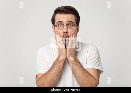 La millenaria uomo caucasico in bicchieri sentirsi sorpreso o turbato Foto Stock