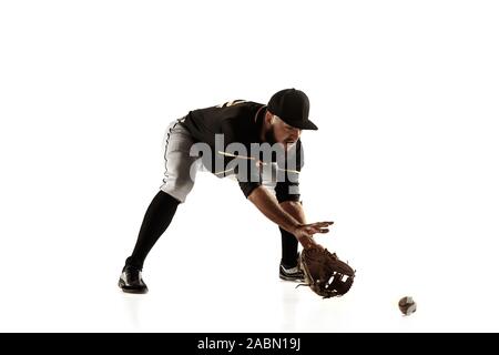 Giocatore di baseball, bricco in un nero uniforme di pratica e formazione isolata su uno sfondo bianco. Giovane atleta professionista in azione e movimento. Uno stile di vita sano, sport, concetto di movimento. Foto Stock