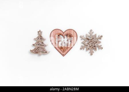 Natale e Anno Nuovo composizione dal golden giocattoli di Natale - Albero di natale, il simbolo del fiocco di neve, a forma di cuore sul giocattolo sfondo bianco. Vista superiore, piana, laici spazio copia Foto Stock