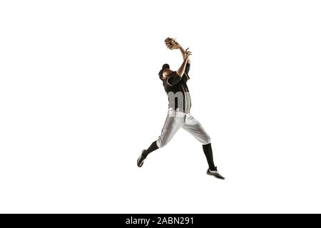 In salto. Giocatore di baseball, lanciatore in nero uniforme di pratica e formazione isolati su sfondo bianco. Giovane atleta professionista in azione e movimento. Uno stile di vita sano, sport, concetto di movimento. Foto Stock