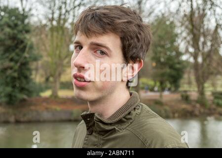 Un giovane uomo nel suo late adolescenti o poco più che ventenne questioningly guarda come se scettico. Foto Stock