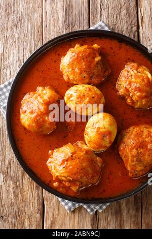 Il cibo Etiope Doro Wat di pollo con le uova in una salsa piccante di close-up in una piastra sul tavolo. Verticale in alto vista da sopra Foto Stock