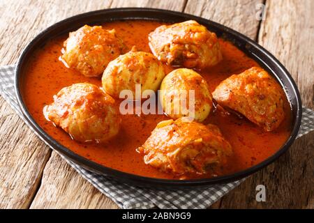 Doro Wat etiope Stufato di pollo bollito lentamente lentamente in una miscela di spezie robusto close-up in una piastra sul tavolo. Posizione orizzontale Foto Stock