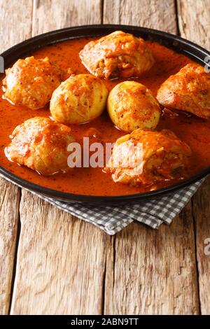 Il cibo Etiope Doro Wat di pollo con le uova in una salsa piccante di close-up in una piastra sul piano verticale. Foto Stock
