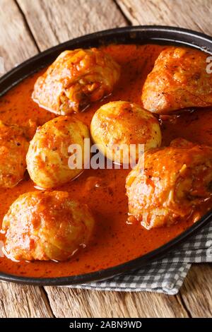 Stufato etiope Doro Wat dal pollo con uova e spezie close-up in una piastra sul piano verticale. Foto Stock
