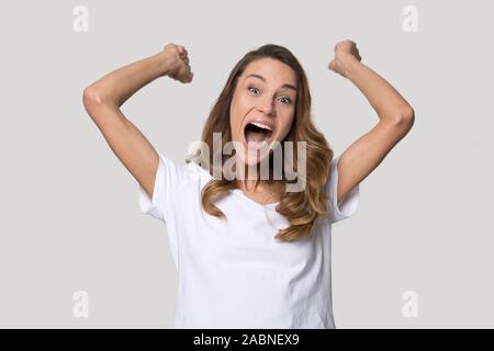 Felice Excited donna celebrando win, alzando le mani, urlando Foto Stock