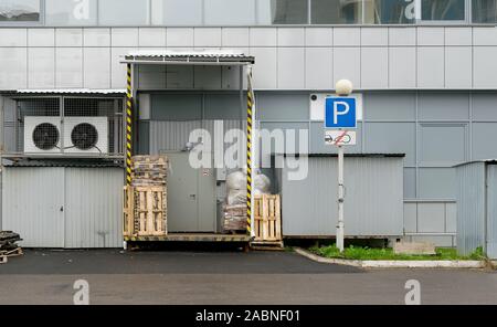 Vista su pallet, contenitori usati, scatole di fronte alla porta del magazzino o dello store Foto Stock