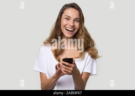 Felice di ridere giovane donna utilizzando cellphone app, divertendosi Foto Stock