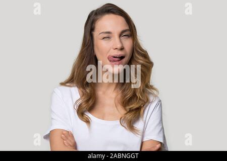 Attraente funny giovane donna che mostra la linguetta e occhiolino Foto Stock