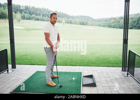 In Pro Golf player volto girato con club in corso. Golfista maschio sul putting green circa per scattare la foto Foto Stock