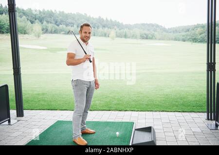 In Pro Golf player volto girato con club in corso. Golfista maschio sul putting green circa per scattare la foto Foto Stock