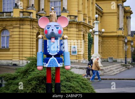 Mouse figura di soldato da lo schiaccianoci statua sul display nel parco di Zagabria per il Mercatino di Natale, con 2 persone a piedi in background Foto Stock