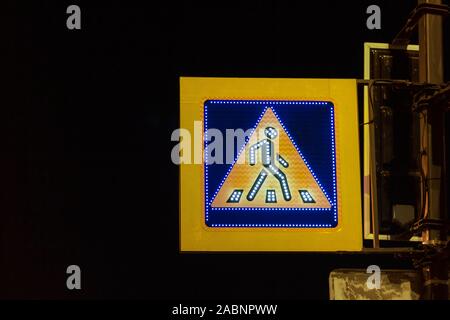 Segno crosswalk incandescente lampeggiante nel buio. attraversamento pedonale illuminazione Foto Stock