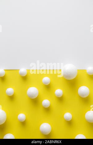La birra di bolle e schiuma costituito da polistirolo sfere su bianco e giallo carta minimo drink creativi dello sfondo. Spazio per la copia. Foto Stock