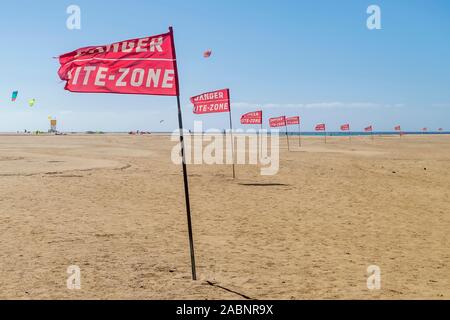Bandiere rosse con avvertimento 'drabbia, kite zone frontaliere dei Playa Sotavento Beach in Fuerteventura, Isole Canarie, Spagna Foto Stock