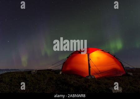 Nordlicht (Aurora boreale) ueber einem erleuchteten Zelt, Moere und Romsdal Fylke, Vestland, Norwegen, Settembre 2011 Foto Stock