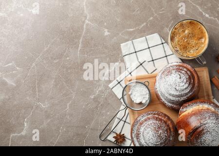 Gustosa cinnamon roll con ingredienti, caffè su sfondo marrone, spazio per il testo. Vista superiore Foto Stock