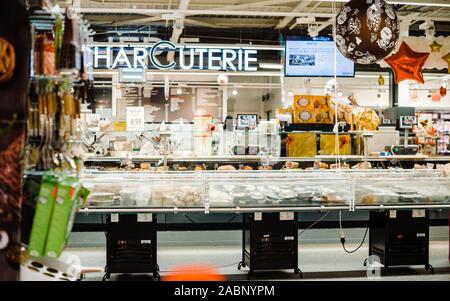 Strasburgo, Francia - Dic 21, 2016: interni di grandi francese supermercati Auchan salumi segno e più la carne e i formaggi prodotti in grande frigorifero Foto Stock