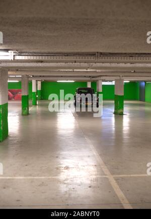 Strasburgo, Francia - Dic 21, 2016: verticale immagine di nero trasformabile cabriolet Volkswagen maggiolino mini auto parcheggiate nel sotterraneo vuoto parete verde parcheggio Foto Stock