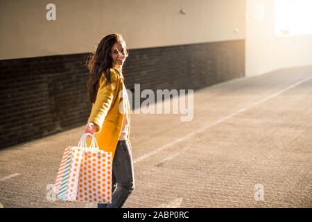 Ritratto di un elegante, giovane e bella donna che è in posa con sacchetti Foto Stock