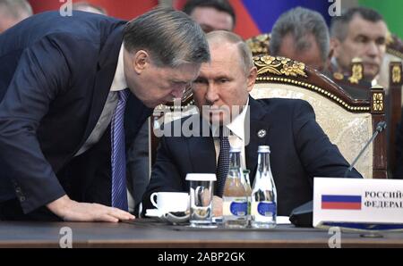 Bishkek, Kirghizistan. 28 Novembre, 2019. Il presidente russo Vladimir Putin parla con Presidential Aide Yury Ushakov durante una sessione del Consiglio di sicurezza collettiva trattato organizzazione presso la stato di Ala-Archa residence Novembre 28, 2019 a Bishkek, Kirghizistan. Credito: Aleksey Nikolskyi Cremlino/Piscina/Alamy Live News Foto Stock