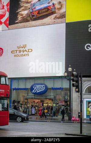 Piccadilly Circus, Londra, Regno Unito. Il 28 novembre 2019. Le luci di Piccadilly Circus si accende un grigio e umido del mattino nel cuore del West End di Londra al di sopra di scarpe pharmacy store. Credito: Malcolm Park/Alamy Foto Stock