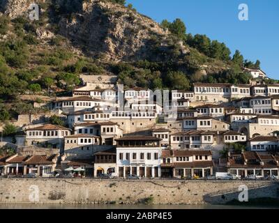 Berat, Albania - 27 Settembre 2019: case Ottomane con finestre multiple costruito sul pendio di una collina in Berat, Albania con il fiume Osum e alle imprese Foto Stock