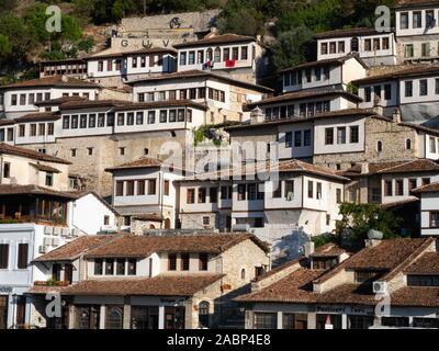 Berat, Albania - 27 Settembre 2019: Ottoman case dipinte di bianco con pareti in stucco, finestre multiple con rivestimento di colore marrone e tetti in terracotta costruito su una h Foto Stock