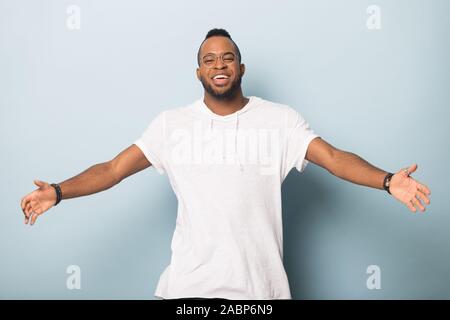Felice friendly African American uomo alzando le mani, offrendo abbracci Foto Stock
