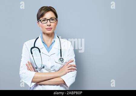 Ritratto di grave medico con stetoscopio guardando la fotocamera.medico medico medico donna blu su sfondo clinica Foto Stock