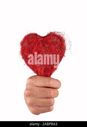 Pugno tenendo un cuore rosso con grande forza Foto Stock