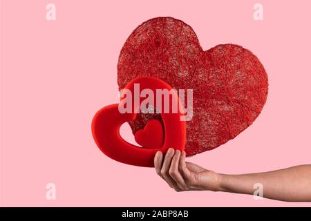 La donna tiene nelle sue mani due cuori. Il giorno di san valentino concetto Foto Stock
