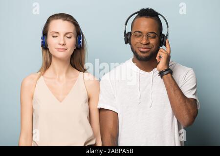 Calma diverse l uomo e la donna nelle cuffie ascoltare musica Foto Stock