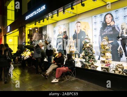 Newcastle upon Tyne, Inghilterra. Regno Unito. 28 Novembre, 2019. Gli amanti dello shopping la preparazione alla coda tutta la notte nel freddo e umido al di fuori di JD Sport nel centro cittadino di Newcastle, sperando di ottenere le loro mani su uno di 250 coppie di Kanye West adidas "Boost Yeezy 350 v2' formatori; rilasciato di nuovo in nero per Venerdì Nero.Credit: ALAN DAWSON/Alamy Live News Foto Stock