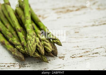 Close up di un mazzetto di asparagi bianchi contro lo sfondo di legno. Foto Stock