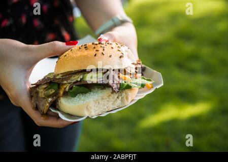 Panino con carne di agnello, spinaci e formaggio fuso ad una street market alimentare. Foto Stock