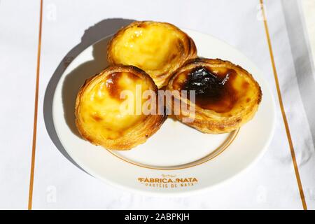 Pasteis de nata, crema pasticcera crostate su una piastra da Fabrica da Nata a Lisbona, Portogallo. Foto Stock