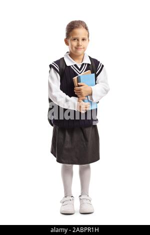 A piena lunghezza Ritratto di un little schoolgirl contenere libri e posa isolati su sfondo bianco Foto Stock