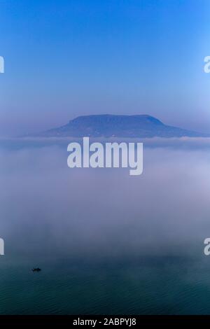 Vista di foggy Balaton from Fonyód promenade con il Badacsony in background su una giornata autunnale. Foto Stock