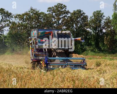 Coppia campo di riso viene raccolta mediante la macchina nel nord della Thailandia Foto Stock