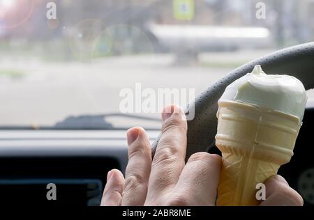 Uomo con gelato al volante di una vettura Foto Stock