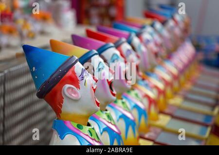 Clown per la palla in bocca gioco sul lato mostra vicolo in un paese mostrano Foto Stock