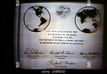 Teleclip - Apollo 17 prese direttamente dallo schermo del televisore durante la trasmissione live da 'Harry' 1972. A sinistra gli astronauti sulla luna all'Taurus-Littrow landing site. Apollo 17 era il finale di atterraggio lunare nella missione della NASA del programma Apollo . La lapide commemorativa è stata svelata al termine della terza attività extravehicular (EVA-3). La placca è stata realizzata in acciaio inossidabile di misura da nove a sette e cinque ottavi di pollice e un sedicesimo di pollice di spessore. Esso è stato fissato per la scaletta sul carrello di atterraggio puntone in fase di discesa degli Apollo 17 Modulo Lunare "Challenger". Foto Stock